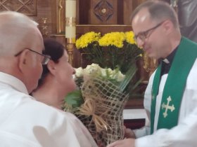 Parafianie wręczają kwiaty księdzu proboszczowi
